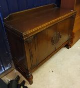 A 1930s oak sideboard with two central cupboard doors enclosing drawers and shelves flanked by two