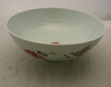 A Chinese bowl polychrome decorated with floral sprays raised on a circular foot bearing faux