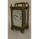 An early 20th Century brass cased carriage timepiece in four pillared case and blind fretwork style