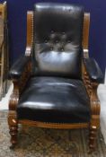 A Victorian salon elbow chair with show frame and buttoned leather back and seat and arms,