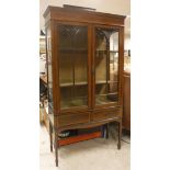 An Edwardian mahogany inlaid and glazed display cabinet above two short drawers on square tapering