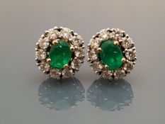 A pair of emerald and diamond set cluster earrings
