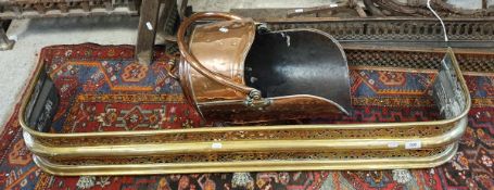 A Victorian copper coal helmet and a Victorian pierced brass fender