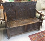An oak box seat settle with carved decoration