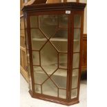 An Edwardian mahogany corner cabinet with astragal glazed door