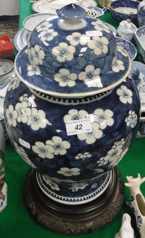 A 19th Century Chinese blue and white prunus blossom decorated baluster shaped vase and cover on a