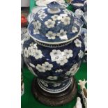 A 19th Century Chinese blue and white prunus blossom decorated baluster shaped vase and cover on a