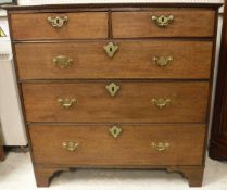 An early 19th Century oak chest of two short over three long drawers to bracket feet