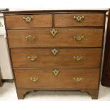 An early 19th Century oak chest of two short over three long drawers to bracket feet