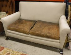 An early 20th Century upholstered two-seat sofa on claw and ball feet in the Georgian style