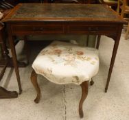 An Edwardian mahogany two drawer writing table on square tapered legs to castors,