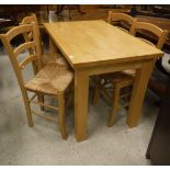 A modern beech kitchen table and four bar-back rush-seated chairs,