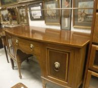 An Edwardian mahogany Sheraton Revival bow fronted sideboard with brass splash rail over a central