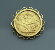 A 1911 gold sovereign in metal mounts. Approx. 10.