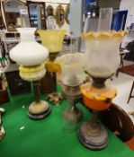 Four various Victorian and later oil lamps with shades and chimneys