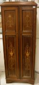 A mahogany and marquetry inlaid two door cupboard of slim proportions in the Sheraton Revival taste
