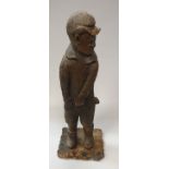 A 19th Century carved wooden figure of a young boy in cap and shorts