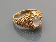 A 9 carat gold ring with aquamarine set stone centre, the shoulders of stylised net design,