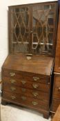 A George III mahogany bureau, the sloping fall opening to reveal a fitted interior,