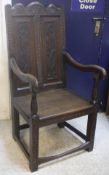 A 19th Century oak panel-seated hall chair, the back with carved foliate decoration,