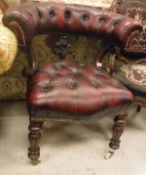 A Victorian upholstered smoker's bow-style chair with buttoned back and seat and carved foliate