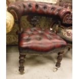 A Victorian upholstered smoker's bow-style chair with buttoned back and seat and carved foliate