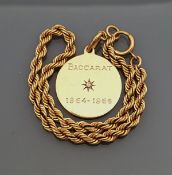 A 14 carat gold tag bracelet, the tag inscribed "Baccarat", set with a diamond and dated 1964-66,