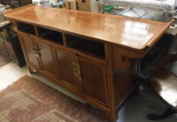 A Chinese cherrywood side cabinet with three drawers over four cupboard doors