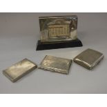 A collection of three silver cigarette boxes / cases and a silver faced desk calendar on ebonised