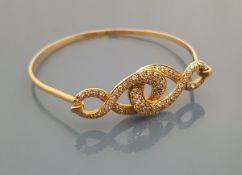 An 18 carat gold multi-diamond set bangle of interlinked figure of 8 form, total weight approx 19.