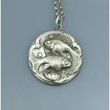 A Georg Jensen pendant depicting two fish (possibly Pisces) with stars and lily,