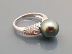 An 18 carat white gold Tahitian style pearl ring with diamond set shoulders, ring size O, 4.