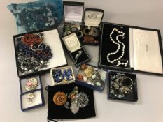 A box containing a quantity of various costume jewellery including necklaces, brooches, etc,