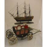 A model of HMS Victory together with a model of a horsedrawn coach and a framed and glazed relief