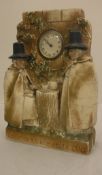 A plaster cased clock decorated in high relief with two Welsh ladies taking tea inscribed "Adcofion