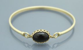 A 9 carat gold cabochon set bangle