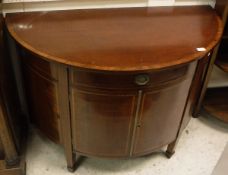 An Edwardian mahogany side cabinet of demi-lune form with single drawer flanked by two dummy