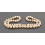 A single strand pearl necklace with 15 carat gold clasp