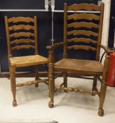 A composite set of fourteen oak chairs with rush seats and shaped ladder backs (12+2)