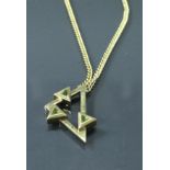 A 9 carat gold geometric design pendant set with green stones, housed on a 9 carat gold chain,