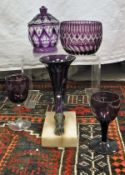 A collection of amethyst and amethyst overlaid cut glass ware including two cornucopia vases,