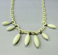 A Giorgio Armani ivory effect resin necklace of large loop and drop form, in Giorgio Armani bag,