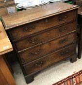 A late George III mahogany chest the plain top with applied moulded edge above four long drawers on