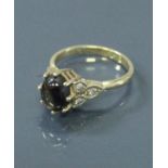 A 9 carat gold dress ring with central star sapphire, flanked by diamond set shoulders,