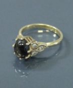 A 9 carat gold dress ring with central star sapphire, flanked by diamond set shoulders,