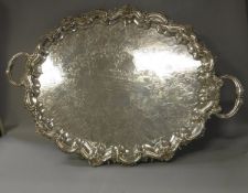 A large silver plated tray in the Rococo taste with all-over scrolling foliate engraved and cast