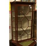 An Edwardian mahogany corner cabinet with astragal glazed door