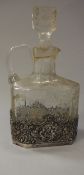 A George V cut glass spirit flagon with pierced silver mount decorated with panels of topers in