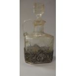 A George V cut glass spirit flagon with pierced silver mount decorated with panels of topers in