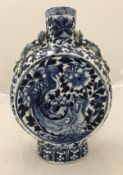 An early 20th Century Chinese blue and white moon flask with relief work dragon handles,